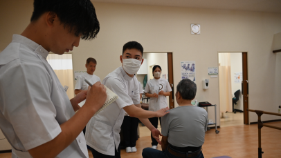 学生が高齢者の姿勢を確認しながら実習を行う様子