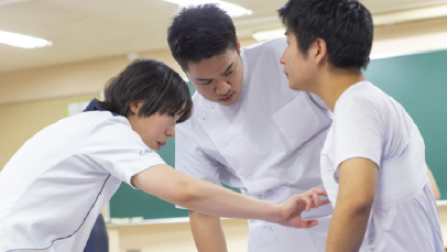 学生が体の動きを確認しながら実技指導を行う様子