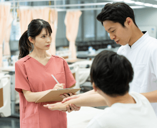 学生が腕の動きを確認しながら実技指導を受けている様子